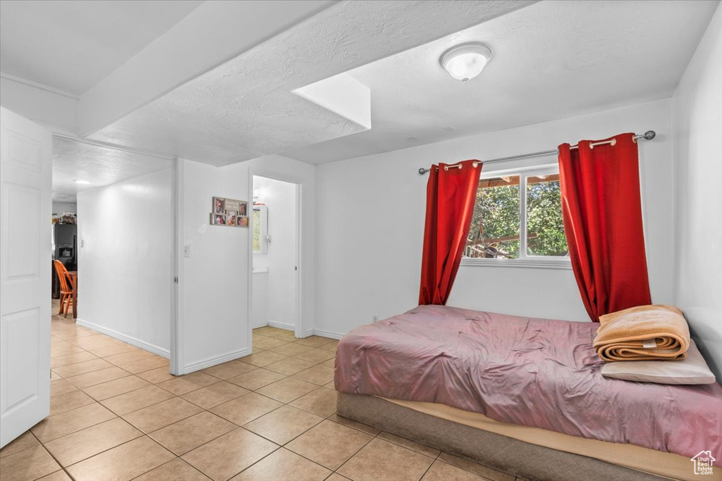 Bedroom with light tile patterned floors and baseboards