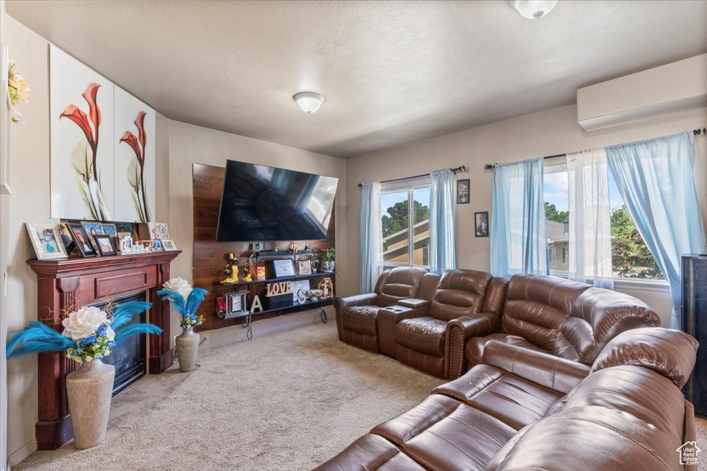 Living area featuring carpet, a wall mounted air conditioner, and a fireplace