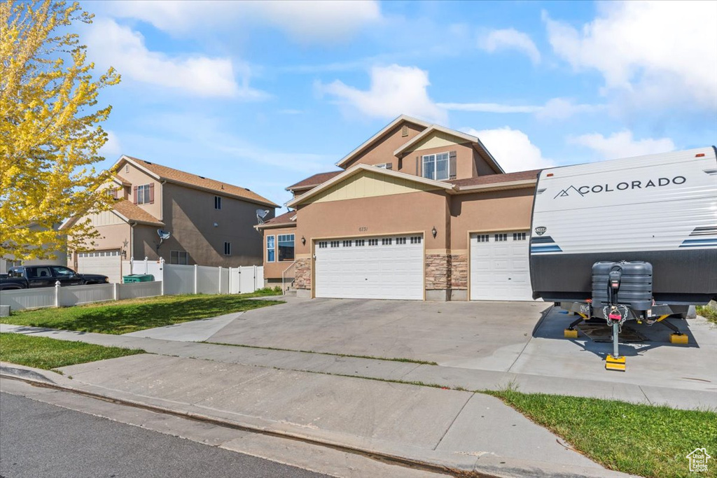 View of front of house featuring stucco siding, concrete driveway, and stone siding