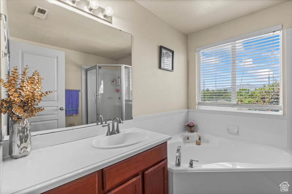 Full bathroom featuring a stall shower, a bath, and vanity