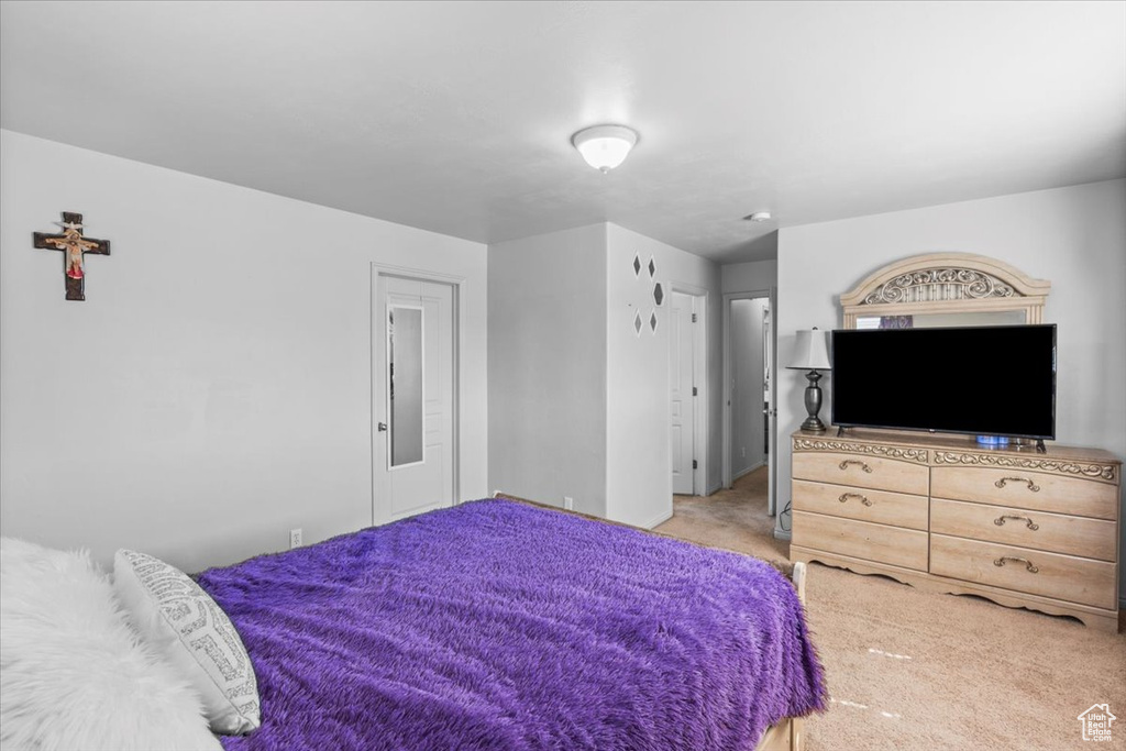 Bedroom with light colored carpet and baseboards