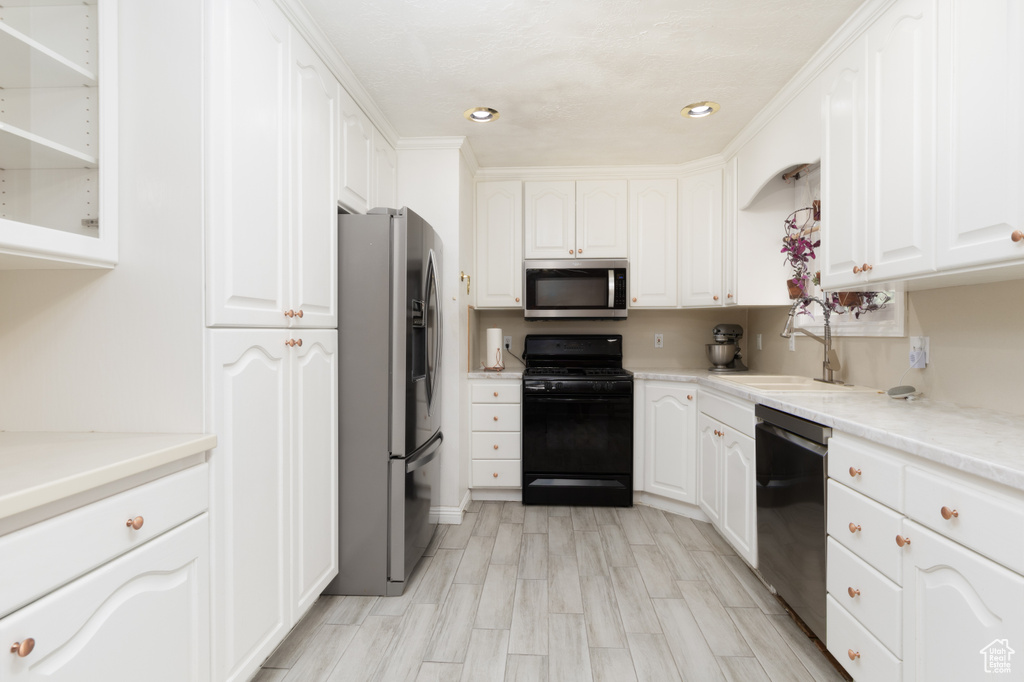 Kitchen featuring appliances with stainless steel finishes, a sink, white cabinets, open shelves, and recessed lighting