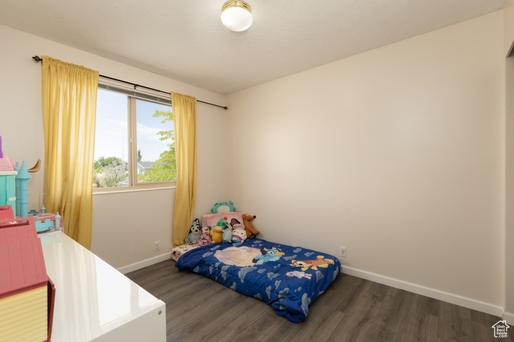 Bedroom with wood finished floors and baseboards