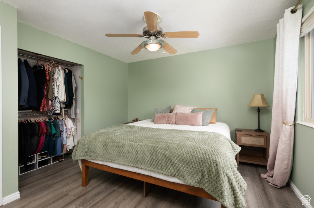 Bedroom with wood finished floors, a closet, baseboards, and a ceiling fan