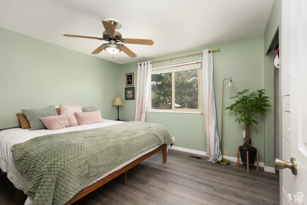Bedroom featuring wood finished floors, baseboards, and a ceiling fan
