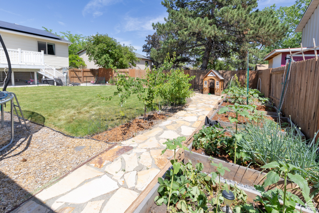 View of yard with a garden, stairs, and a deck