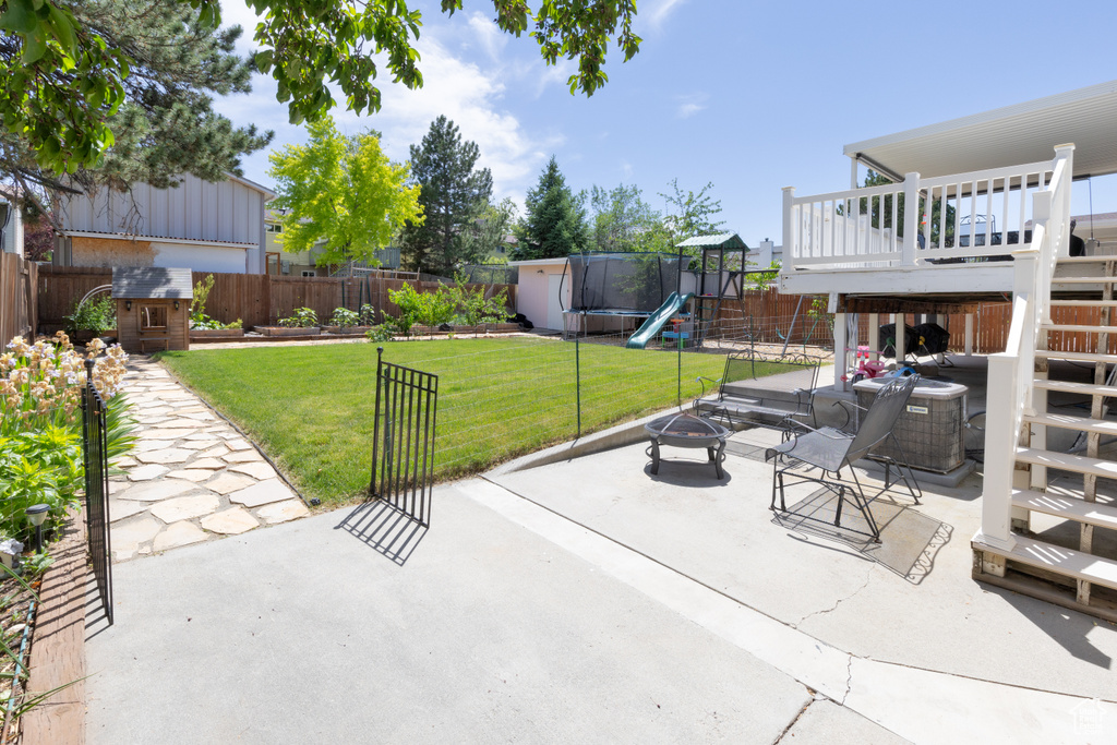 View of patio / terrace with a fire pit, a playground, a trampoline, and stairs