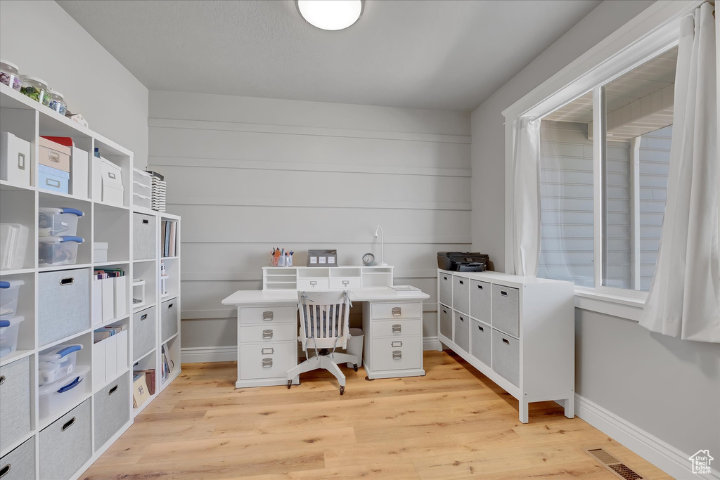 Office area featuring light wood-style floors and baseboards