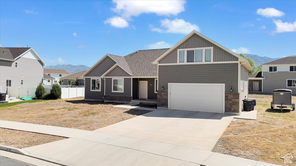 Craftsman inspired home featuring a mountain view, concrete driveway, an attached garage, and central AC