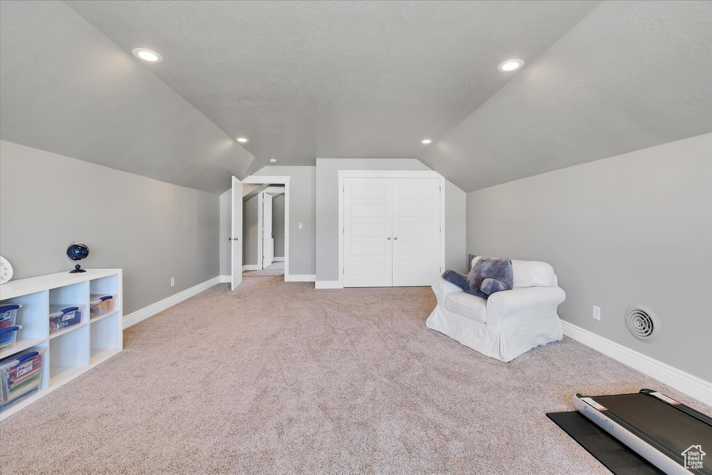 Living area featuring vaulted ceiling, carpet floors, recessed lighting, and baseboards