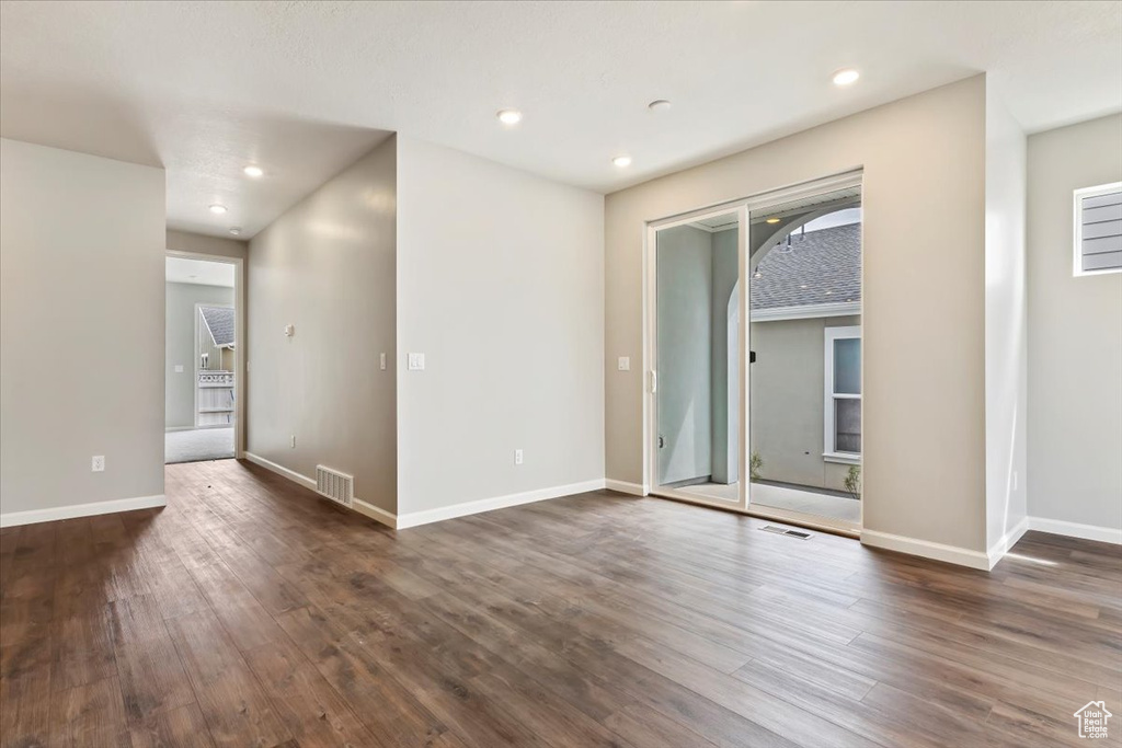 Unfurnished room with dark wood-style floors, baseboards, and recessed lighting