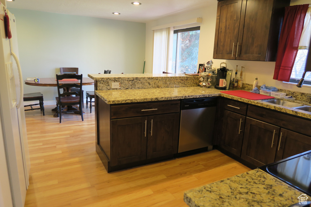 Kitchen with stainless steel dishwasher, light wood-style floors, a peninsula, a sink, and recessed lighting