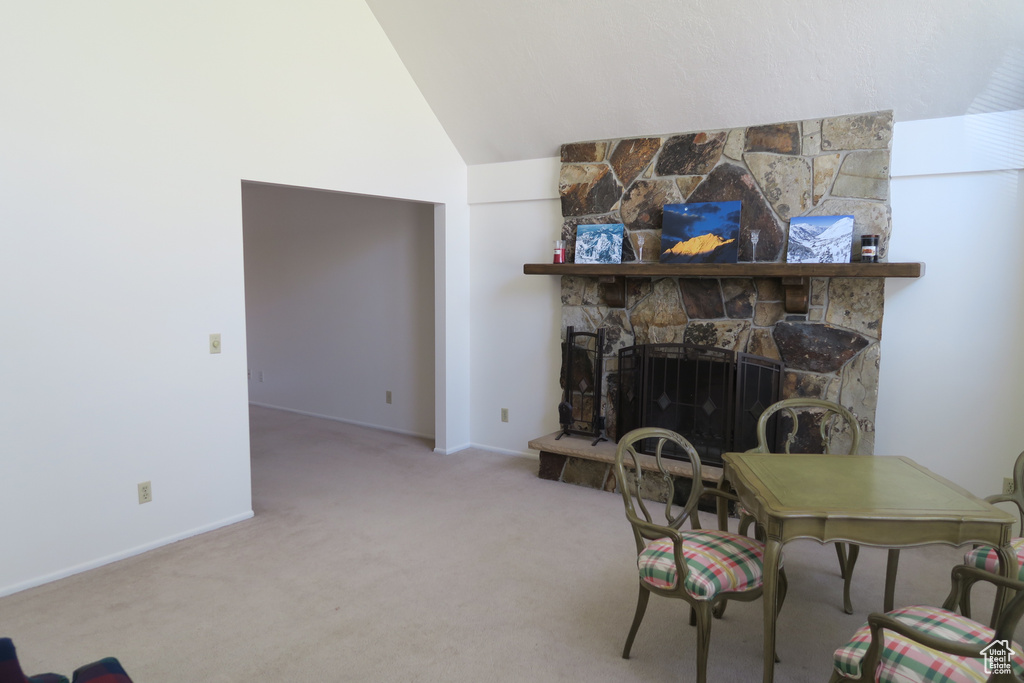 Living area featuring carpet, baseboards, a fireplace, and high vaulted ceiling