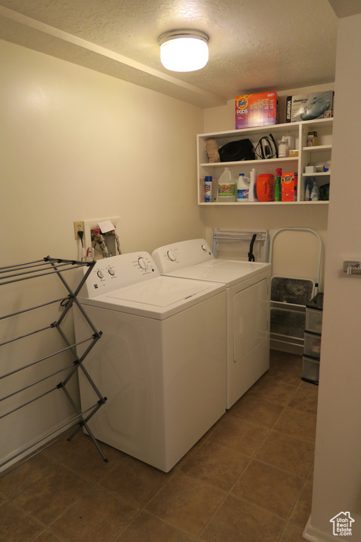 Laundry area featuring independent washer and dryer, a textured ceiling, and tile patterned flooring