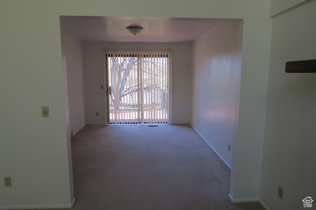 Carpeted spare room featuring baseboards