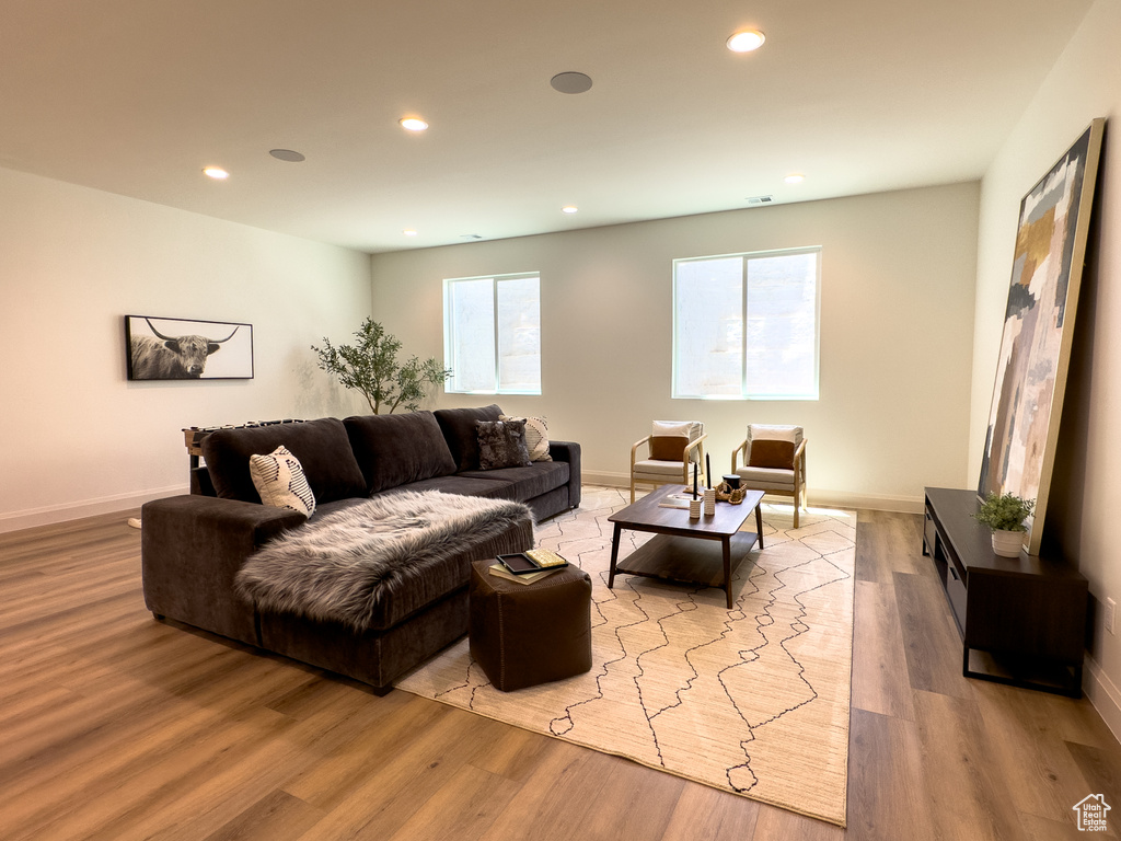 Living room with recessed lighting, wood finished floors, plenty of natural light, and baseboards