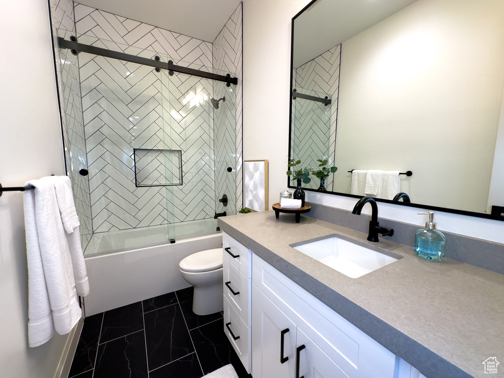 Bathroom with vanity, toilet, combined bath / shower with glass door, and marble look tile flooring
