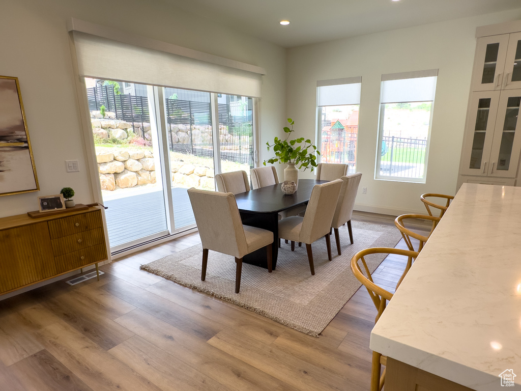 Dining room with plenty of natural light, light wood-style flooring, and recessed lighting