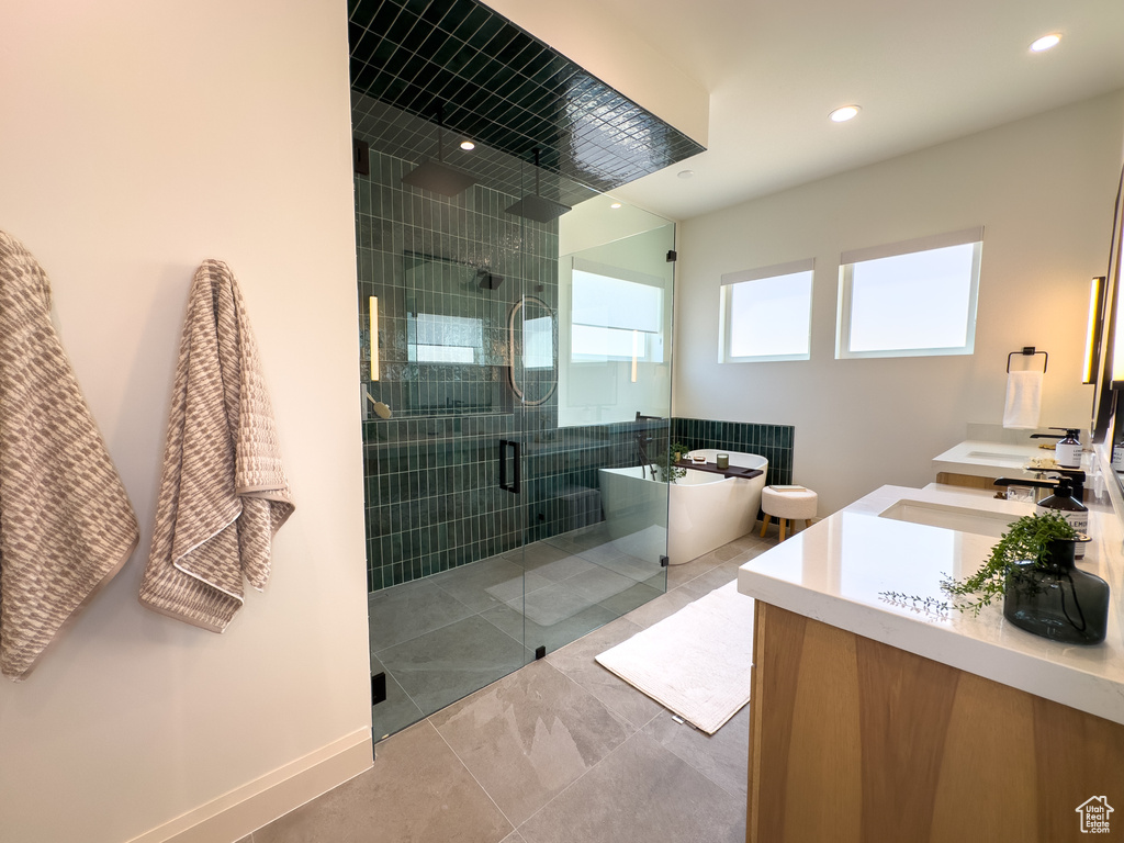 Full bath featuring a stall shower, a soaking tub, double vanity, recessed lighting, and tile patterned floors