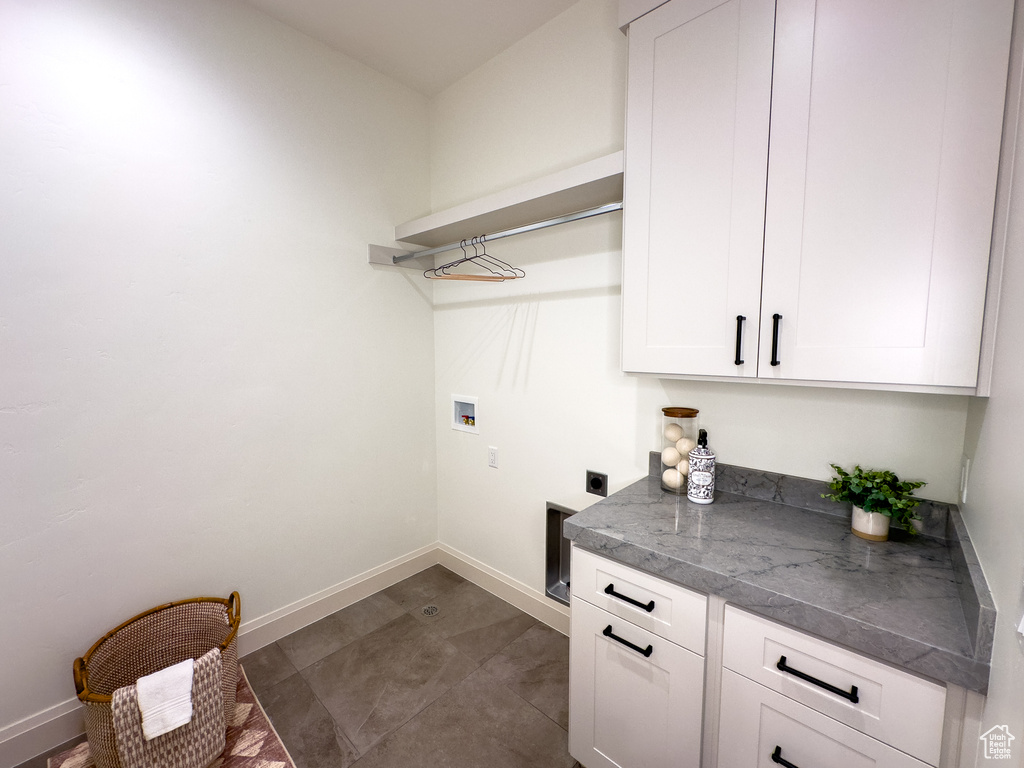 Laundry room featuring cabinet space, hookup for a washing machine, electric dryer hookup, and baseboards