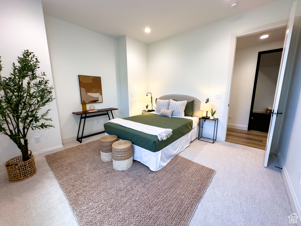 Bedroom with light carpet, recessed lighting, and baseboards