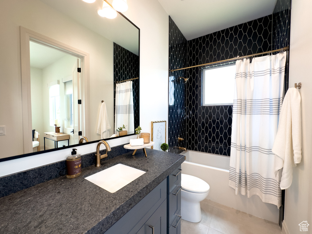 Full bathroom featuring toilet, vanity, shower / bath combo, and tile patterned flooring