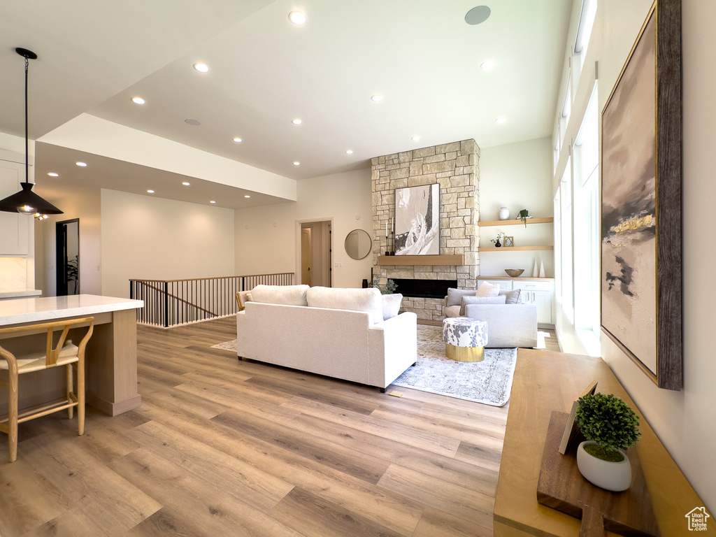 Living area featuring light wood finished floors, recessed lighting, and a fireplace