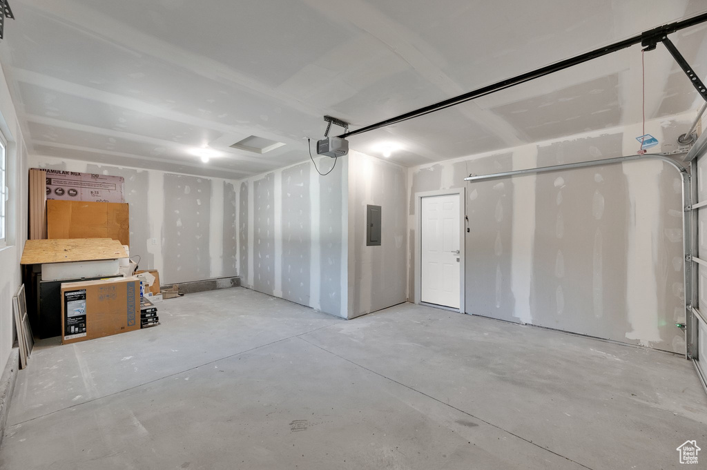 Garage featuring electric panel and a garage door opener