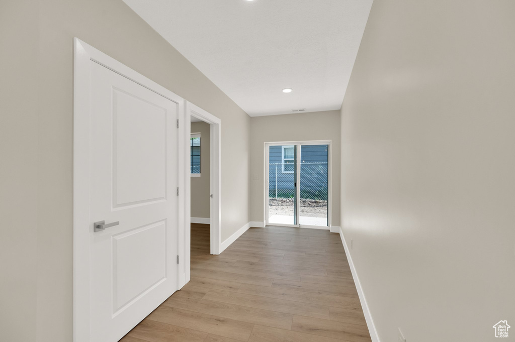 Corridor with baseboards, light wood finished floors, and recessed lighting
