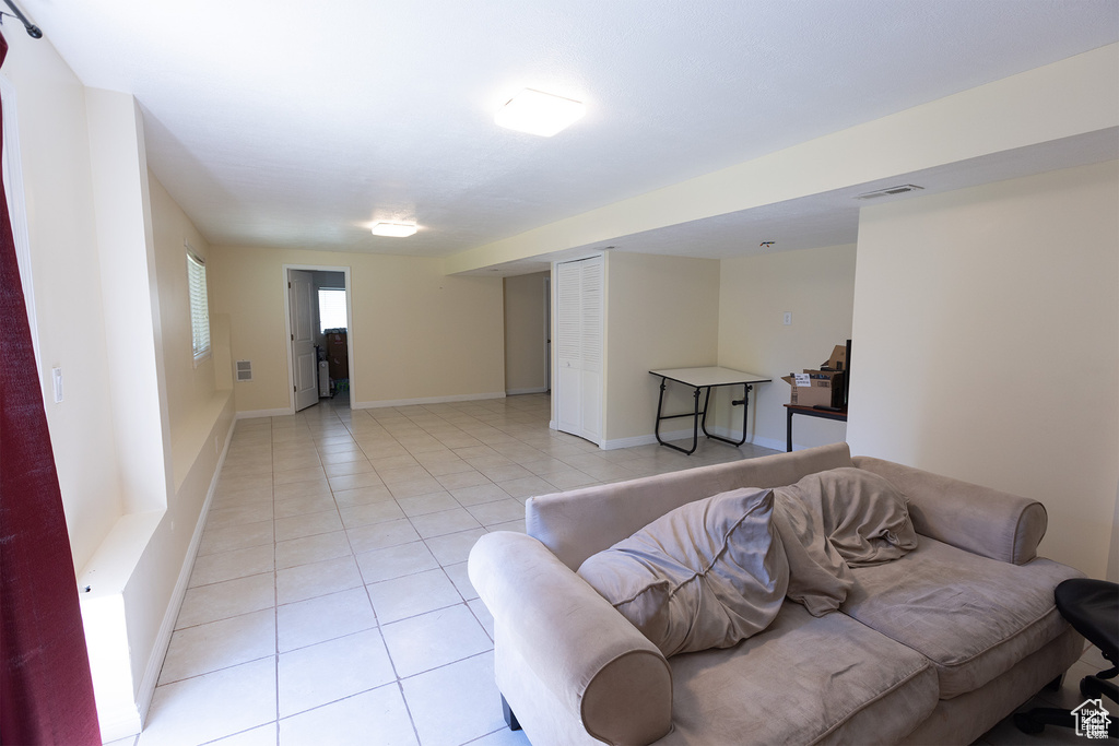 Living room with light tile patterned flooring and baseboards