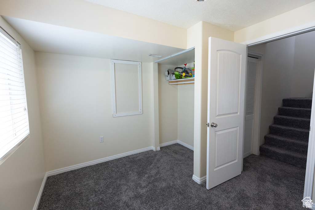 Unfurnished bedroom with carpet flooring, multiple windows, and baseboards
