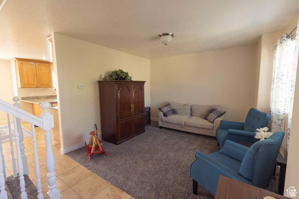 Living room with light carpet, light tile patterned flooring, and baseboards
