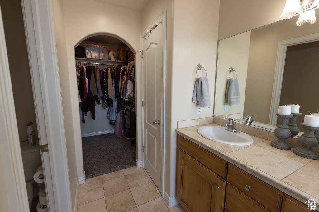 Bathroom featuring vanity, a spacious closet, and tile patterned flooring
