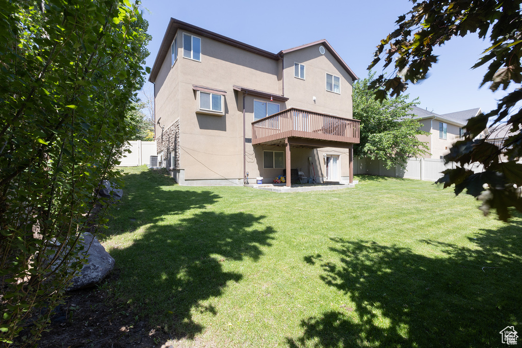 Rear view of property with a deck, central AC, and stucco siding