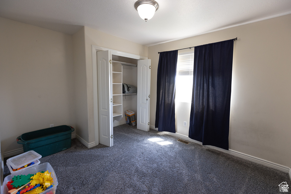 Unfurnished bedroom with carpet flooring, a closet, and baseboards