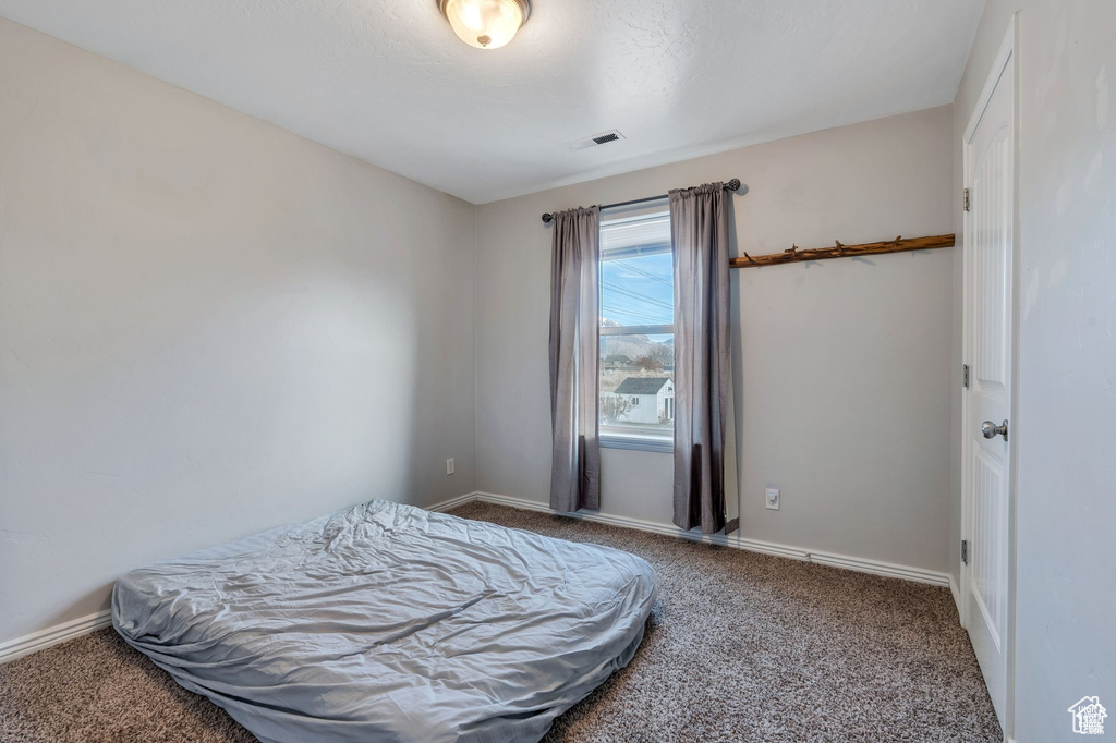 Bedroom featuring carpet and baseboards