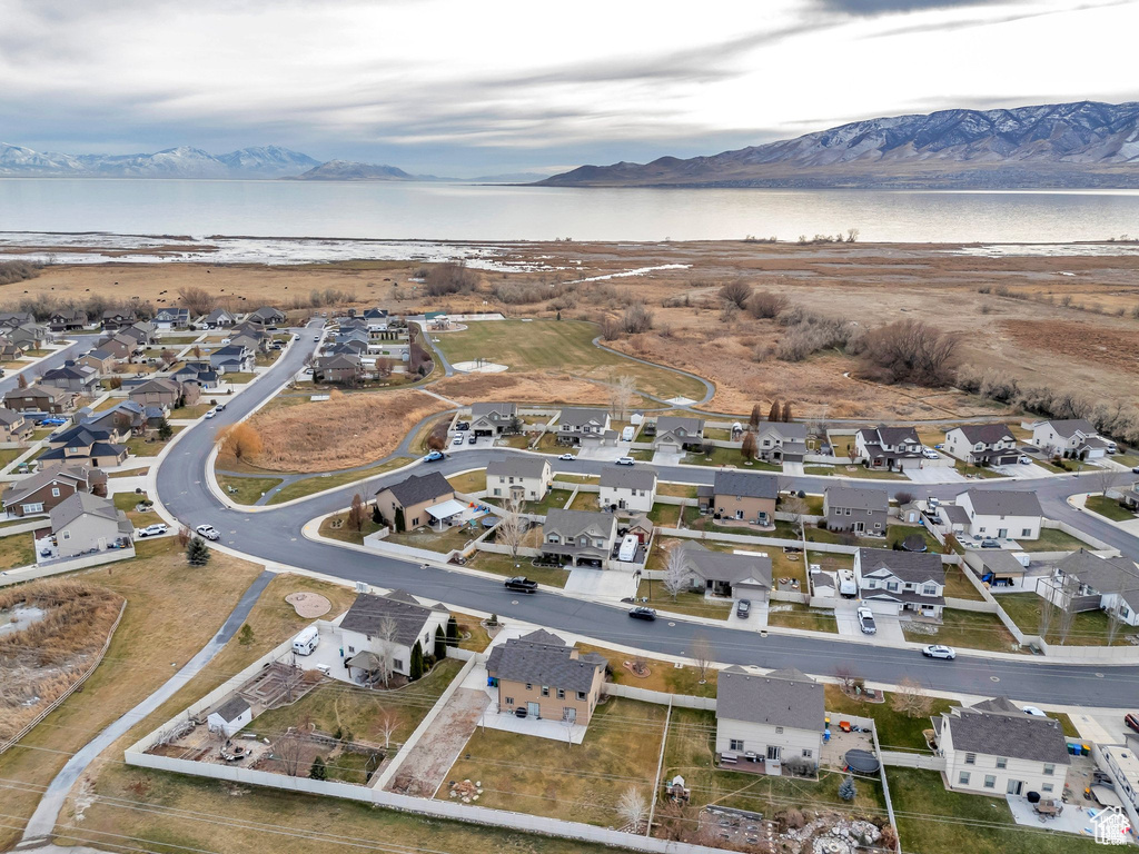Aerial view of property and surrounding area featuring a water and mountain view and nearby suburban area
