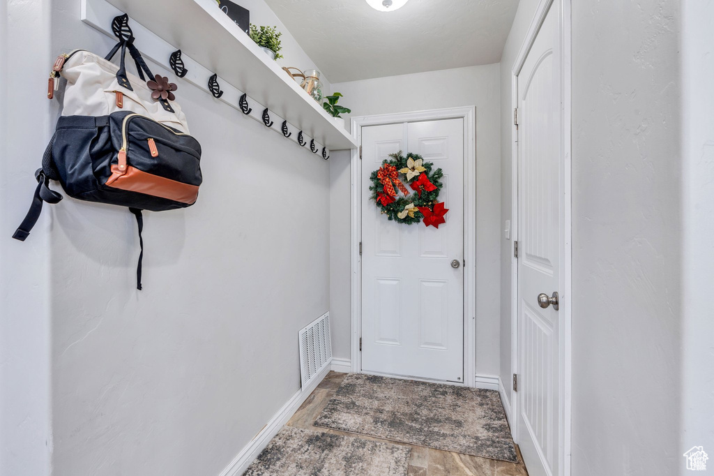 Doorway with wood finished floors and baseboards