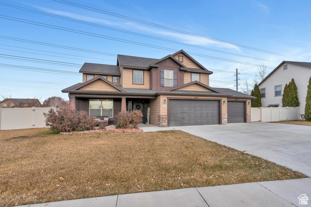View of front of home featuring concrete driveway, a gate, an attached garage, stone siding, and a porch