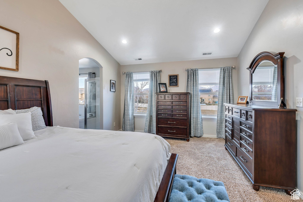 Bedroom featuring vaulted ceiling, light carpet, arched walkways, recessed lighting, and baseboards