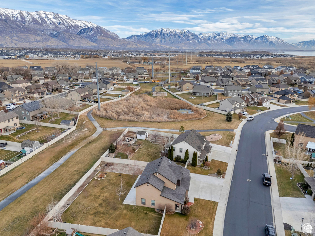 Aerial view of property and surrounding area featuring nearby suburban area and mountains
