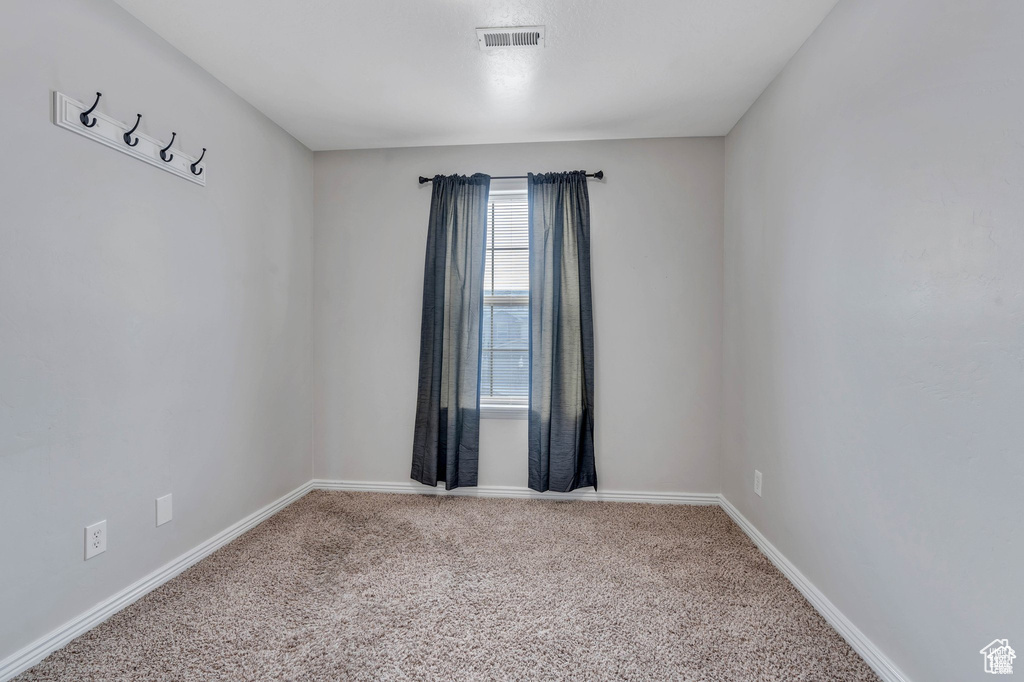 Carpeted empty room featuring baseboards