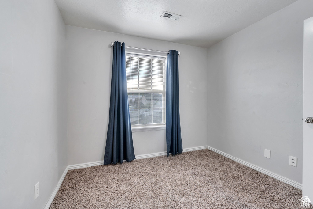 Empty room featuring carpet flooring and baseboards