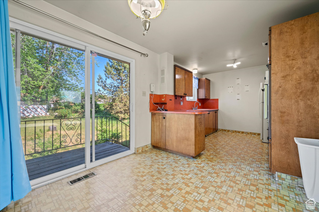 Kitchen with a peninsula, plenty of natural light, and freestanding refrigerator
