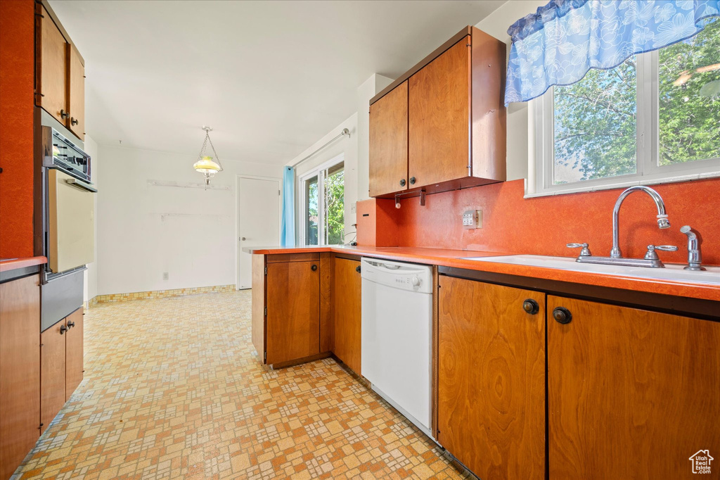 Kitchen with white appliances, a warming drawer, a sink, light countertops, and tasteful backsplash