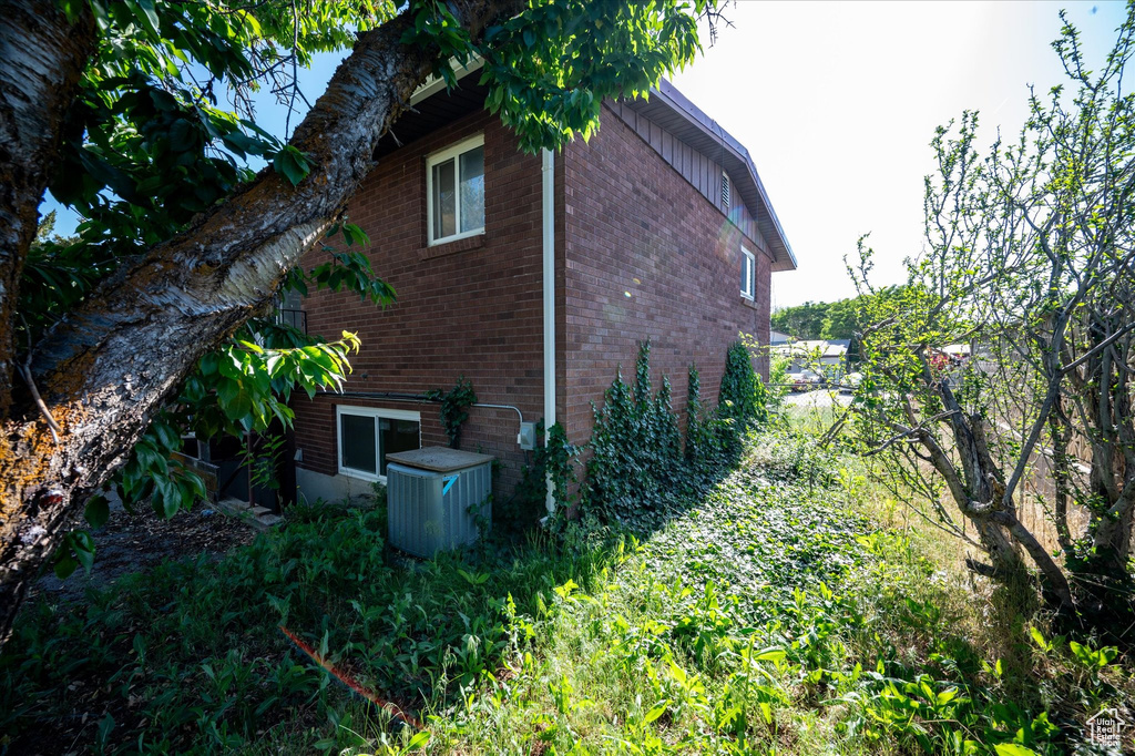 View of property exterior featuring brick siding and central AC unit