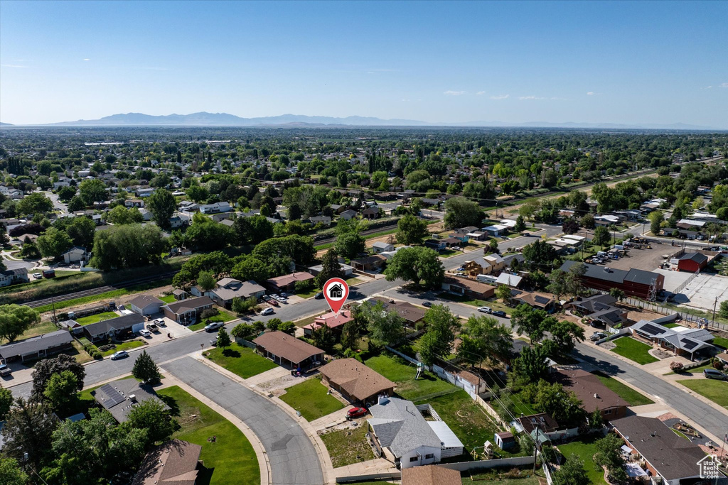 Aerial view of property and surrounding area with nearby suburban area and a mountainous background
