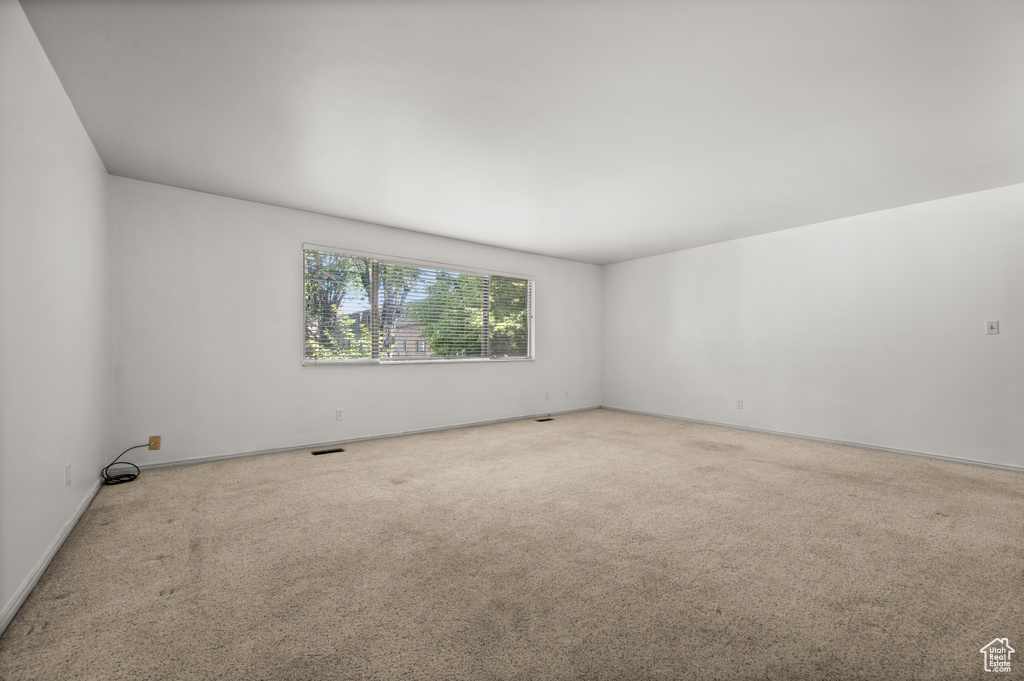 Carpeted spare room with baseboards