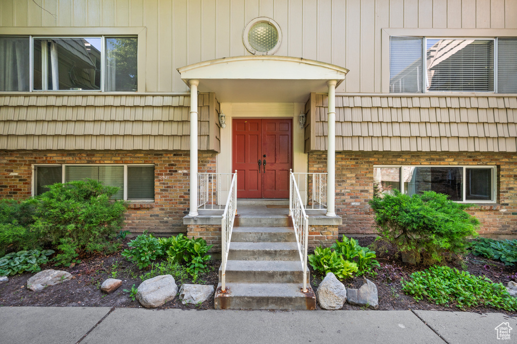 Property entrance featuring brick siding and mansard roof