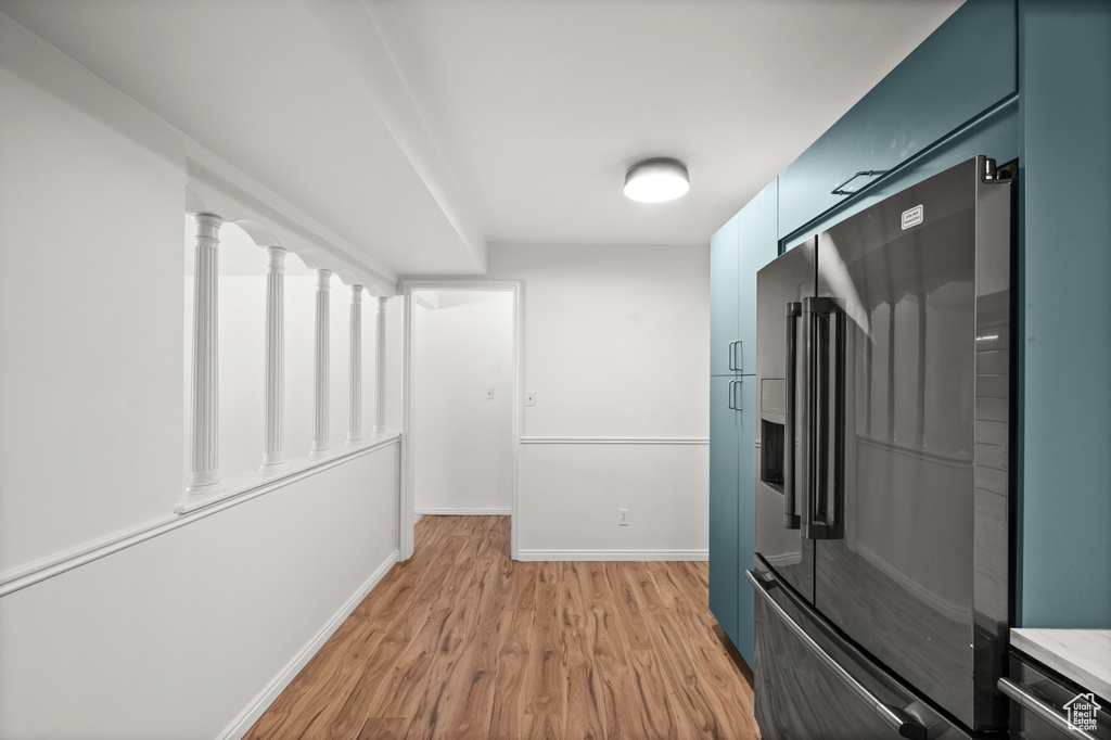 Corridor featuring light wood-style flooring and baseboards